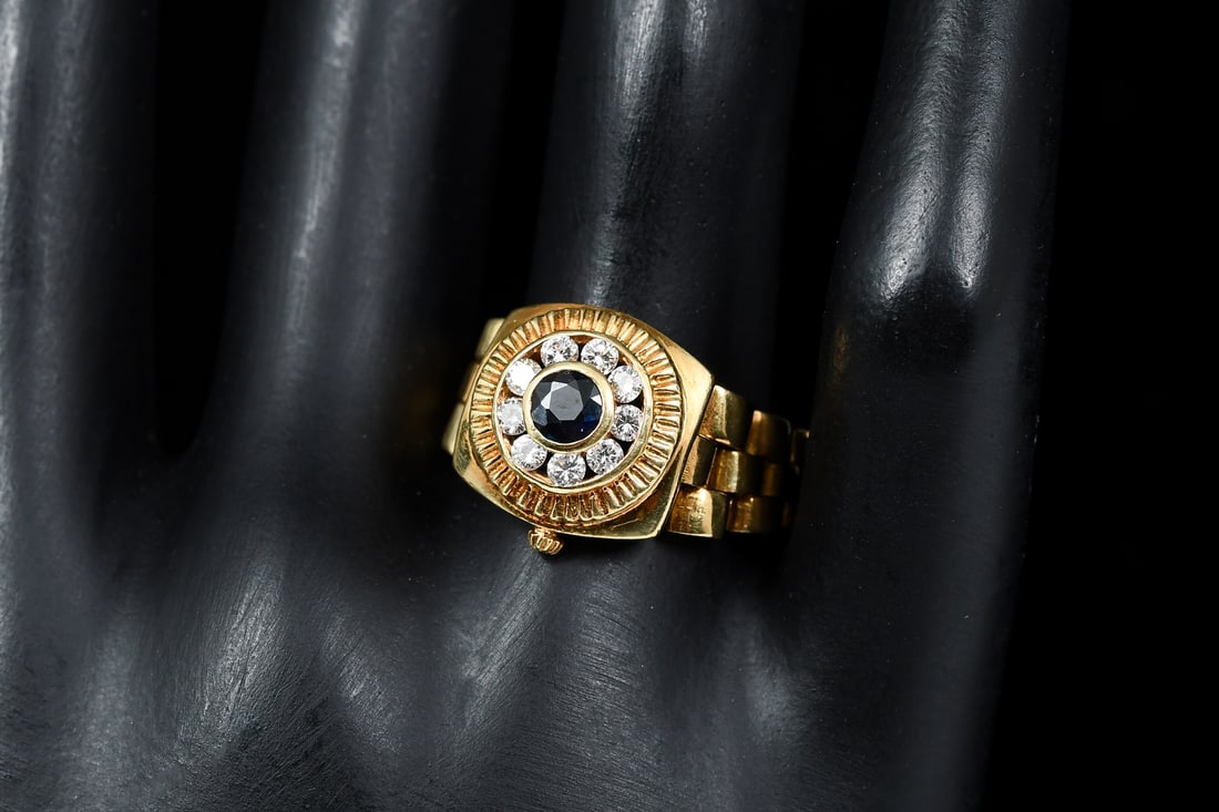 18K GOLD SAPPHIRE & DIAMOND ROLEX STYLE FLEX RING: 18K GOLD SAPPHIRE & DIAMOND ROLEX STYLE FLEX RING: 18K yellow gold vintage Italian "Rolex" style flex ring containing sapphires and diamonds. Ring size: 9. 10.50 CTW. Weight: 10.26 grams.