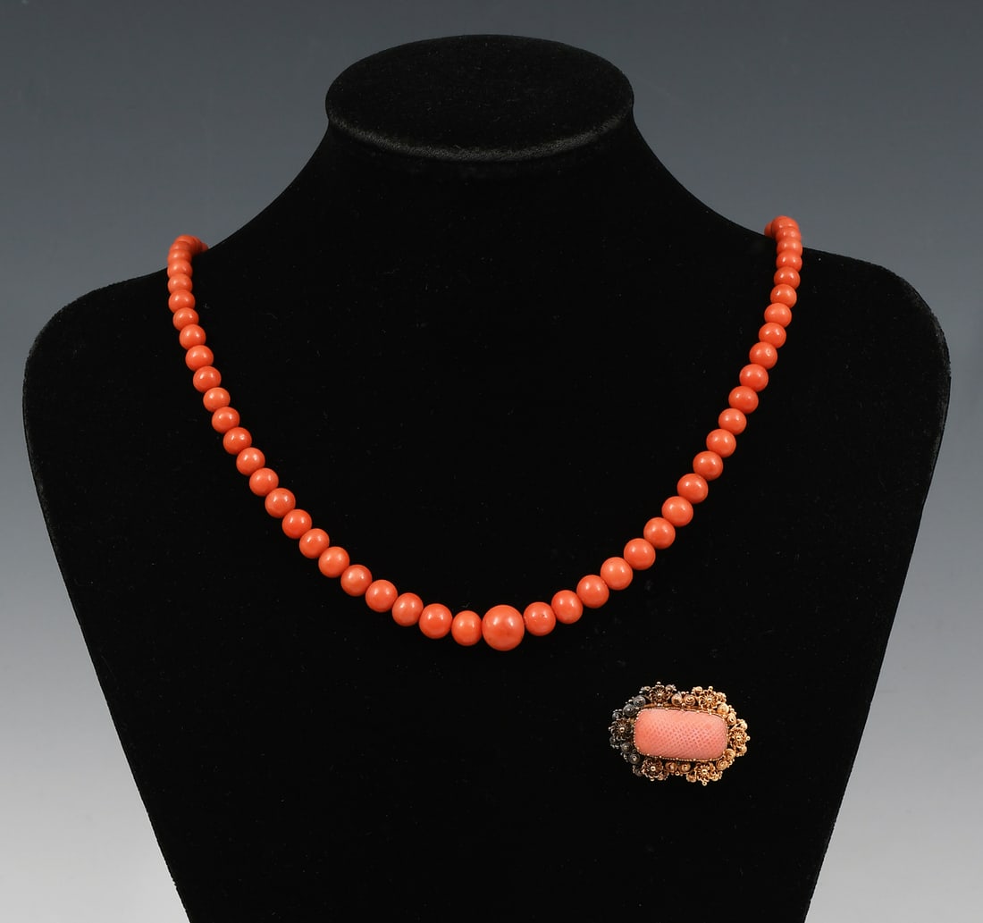 14K GOLD & CORAL BROOCH & NECKLACE: 14K GOLD & CORAL BROOCH & NECKLACE: A vintage graduated coral bead necklace. Length approximately 21", weight 32.9 grams and an ornate, oblong brooch with a rectangular cabochon coral. Approximate dim