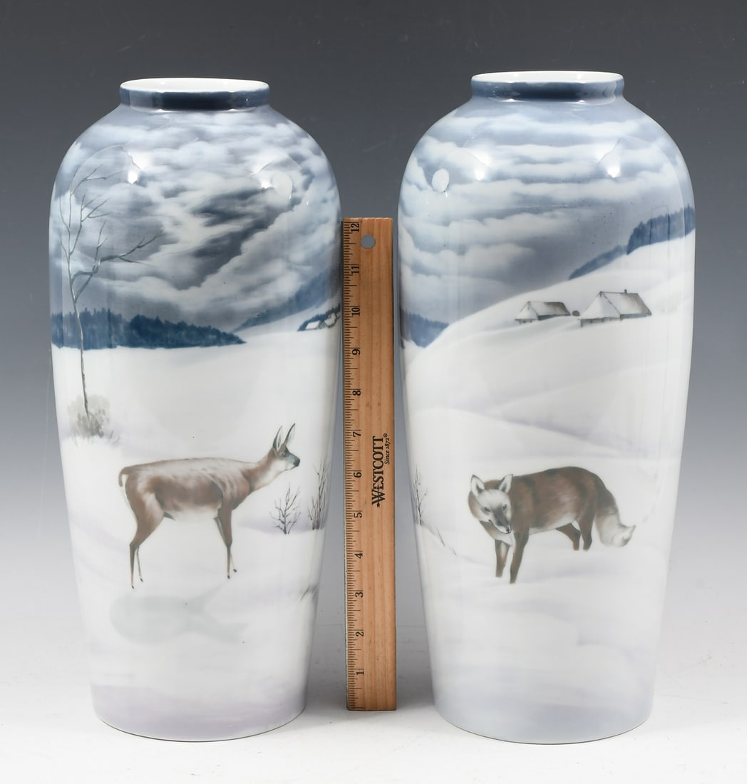 PR. CZECHOSLOVAKIA DUCHCOV PORCELAIN FIGURAL VASES: PR. CZECHOSLOVAKIA DUCHCOV PORCELAIN FIGURAL VASES: A set of two Dux Duchcov Czechoslovakian vases, one with a Fox in the Snow with cabins and forest in the background, the other has a Deer in the Sno