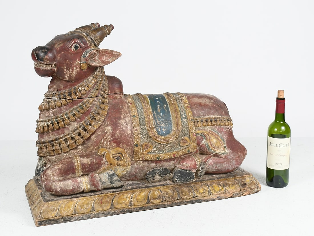 EAST INDIAN CARVED & PIGMENT DECORATED WOOD BULL: EAST INDIAN CARVED & PIGMENT DECORATED WOOD BULL: Antique carved & decorated sculpture of the Hindu deity Nandi, the sacred Bull mount of Lord Shiva. Approx. 22.5" h x 29.25" w x 11" d.