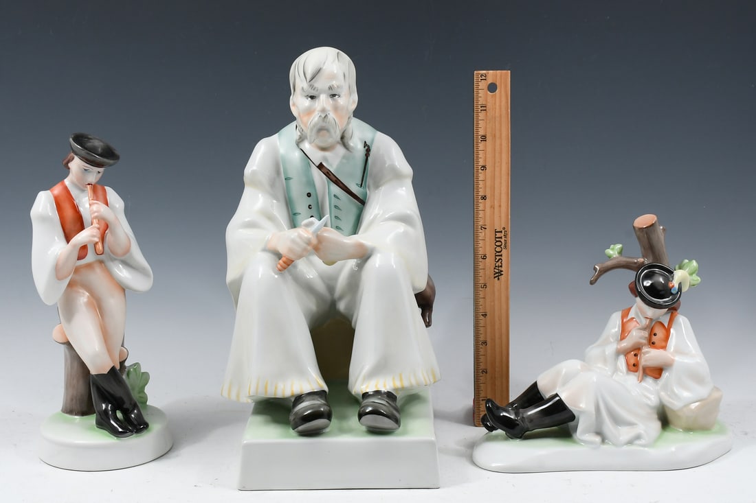 3 PC. LARGE HUNGARIAN ZSOLNAY PORCELAIN FIGURES: 3 PC. LARGE HUNGARIAN ZSOLNAY PORCELAIN FIGURES: Comprising; 1- Seated Whittling Man, 2- Reclining men playing a Flute. Largest Approx. 13" h x 9" w x 7" d.