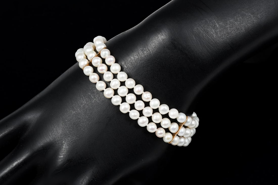 14K GOLD TRIPLE STRAND PEARL BRACELET: 14K GOLD TRIPLE STRAND PEARL BRACELET: An elegant pearl bracelet of 3 strands with a 14K yellow gold filigree clasp and 2 14k yellow gold spacer bars. The pearls are irregular in shape. Length approxi
