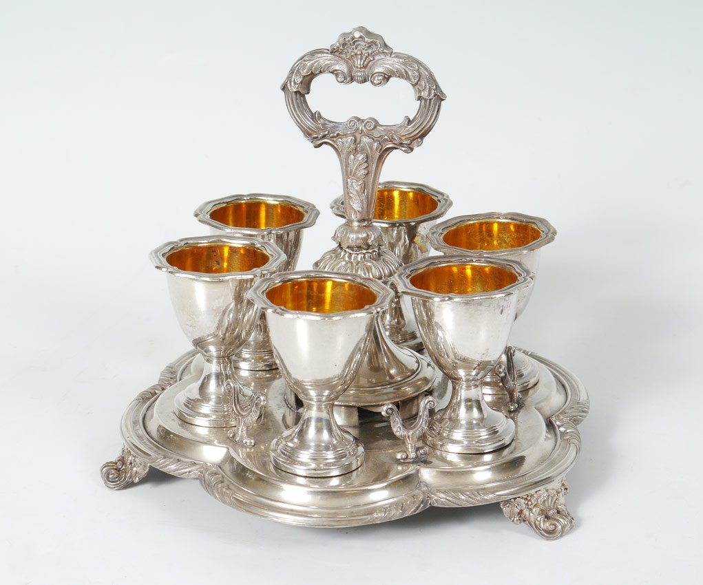 SILVERPLATE EGG CUP STAND: SILVERPLATE EGG CUP STAND: Unmarked as to maker, holds 6 egg cups with vermeil interiors. Overall measures 7 3/4'' h. x 8 3/4''.