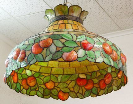 VINTAGE LEADED GLASS HANGING LIGHT: VINTAGE LEADED GLASS HANGING LIGHT: In a "blown out" peach, pomegranate, or orange design. 2 sockets, decorative brass cuff. Approx. 25" dia., 19"h.