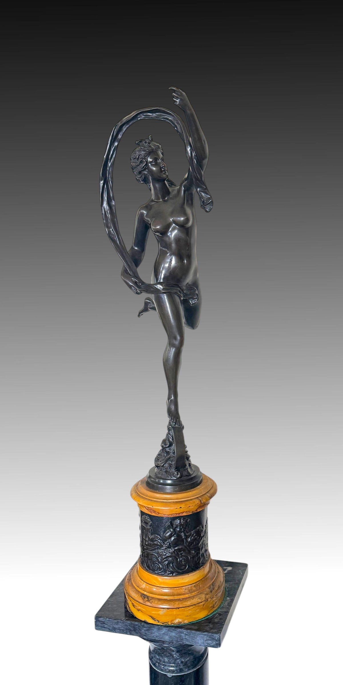 FORTUNA BRONZE AFTER GIAMBOLOGNA: FORTUNA BRONZE AFTER GIAMBOLOGNA: Bronze after the antique by Giambologna. Measures 25" in height, sits atop a circular base with additional bronze relief panels, 33.5" in height overall.