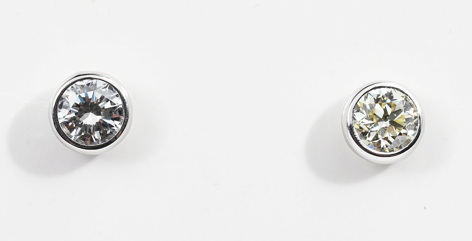 PLATINUM EYEWIRE BEZEL DIAMOND STUDS: PLATINUM EYEWIRE BEZEL DIAMOND STUDS: Platinum diamond earrings contain 2 round brilliant cut diamonds. WEIGHT: 1.05 Ct. Approx. Rated VS in clarity and H-I in color. The diamonds are bezel set. Post 