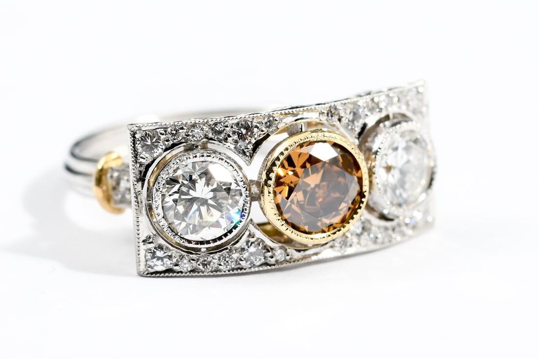 PLATINUM 18K 3-STONE RING: PLATINUM 18K 3-STONE RING: Platinum and 18K yellow gold diamond ring that contains one transitional round brilliant cut diamond. Weight: 1.02 approximate. Rated SI1 in clarity and fancy deep brown in 
