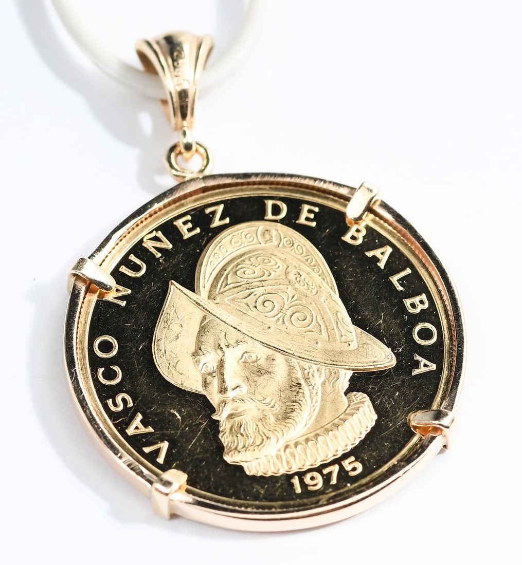 14K FRAME W/ 1975 .900 PANAMA 100 BALBOAS: 14K FRAME W/ 1975 .900 PANAMA 100 BALBOAS: 14K yellow gold coin frame contains one .900 100 Balboas Vasco Nunez de Balboa coin of the Republic of Panama. Total weight: 11.0 grams.
