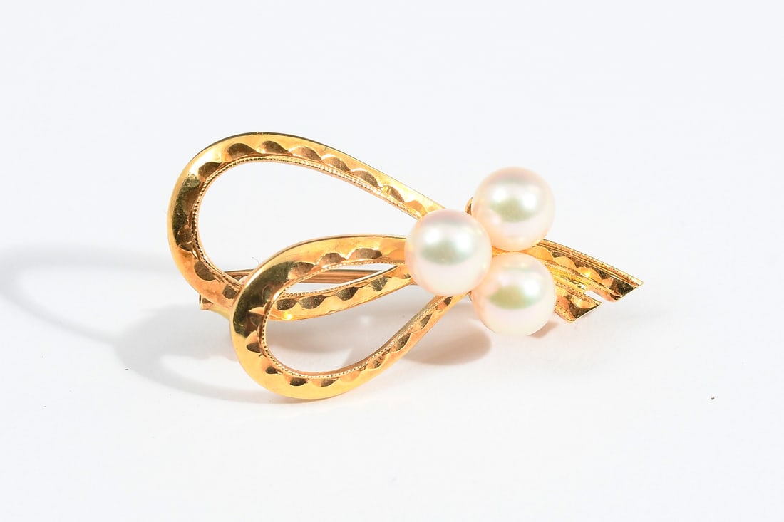 18K GOLD MIKIMOTO PEARL BROOCH: 18K GOLD MIKIMOTO PEARL BROOCH: 18K cultured pearl brooch with three 5.00-5.50 mm cultured pearls. White with pink overtone. Mikimoto grade: AA quality. Locking bar pin closure. Weight: 4.4 grams.