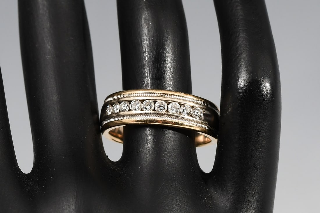14K GOLD .50 CTW DIAMOND BAND: 14K GOLD .50 CTW DIAMOND BAND: 14K two tone gold band contains 9 round brilliant cut diamonds. WEIGHT: .50 Ct. Approx. Rated VS in clarity and G-H in color. The diamonds are channel set. Ring size: