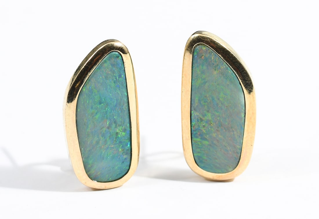14K BOULDER OPAL EARRINGS: 14K BOULDER OPAL EARRINGS: 14K yellow gold earrings contain 2 freeform 20.00 x 10.00 mm blue/green boulder opals. The opals are bezel and epoxy set. Post and hinged clip closures. Gold weight: approxi