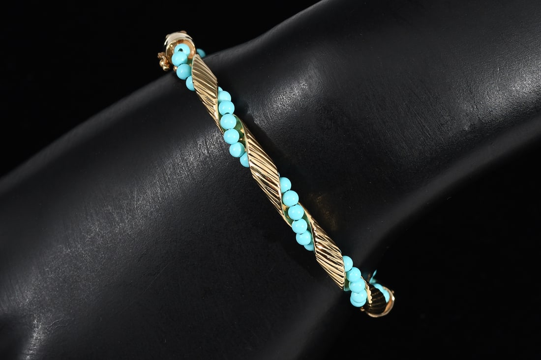 18K TURQUOISE BANGLE BRACELET: 18K TURQUOISE BANGLE BRACELET: 18K yellow gold twisted bangle bracelet with 3.00 mm turquoise beads. The beads are wire strung. Hinged bangle with figure eight safety clasp. Total weight: 9.3 grams.