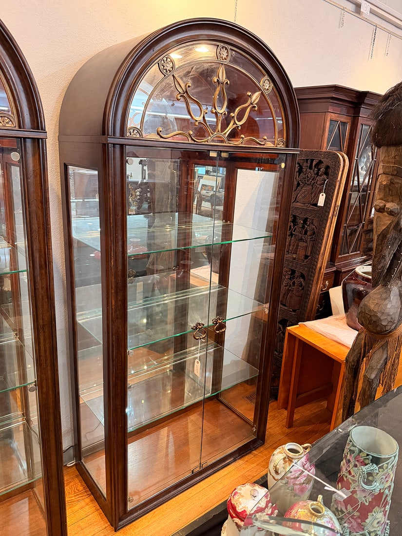 ELEGANT THOMASVILLE LIGHTED DISPLAY CURIO CABINET: ELEGANT THOMASVILLE LIGHTED DISPLAY CURIO CABINET: Contemporary, mahogany finish, having an arched bonnet with decorative brass-finished metal grille, beveled glass doors, mirrored interior, adjustabl