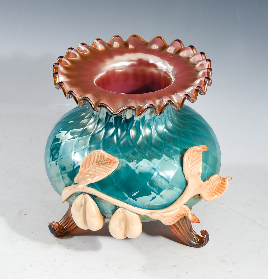 STEVENS & WILLIAMS IRIDESCENT ART GLASS VASE: STEVENS & WILLIAMS IRIDESCENT ART GLASS VASE: Diamond quilted Iridescent body with ruffle rim, applied fruit and leaves. Raised on scrolled feet Etched mark at pontil. Approx. 7.75" h x 7.875" w x 8.1
