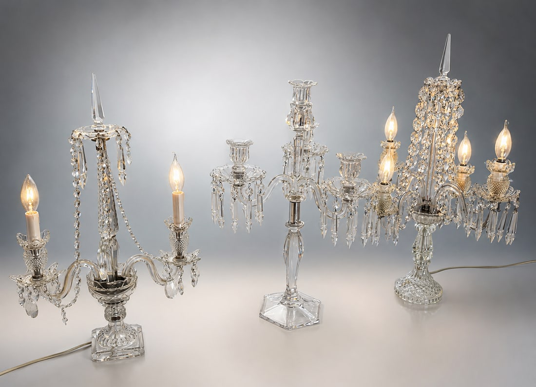 3 CRYSTAL & GLASS PRISMED LAMP & CANDELABRAS: 3 CRYSTAL & GLASS PRISMED LAMP & CANDELABRAS: Comprising; 1- Electrified Two-Light Glass lamp with multi-faceted crystals. 2- Crystal Three-Light Candelabras, adorned by multi-faceted prisms. Largest 