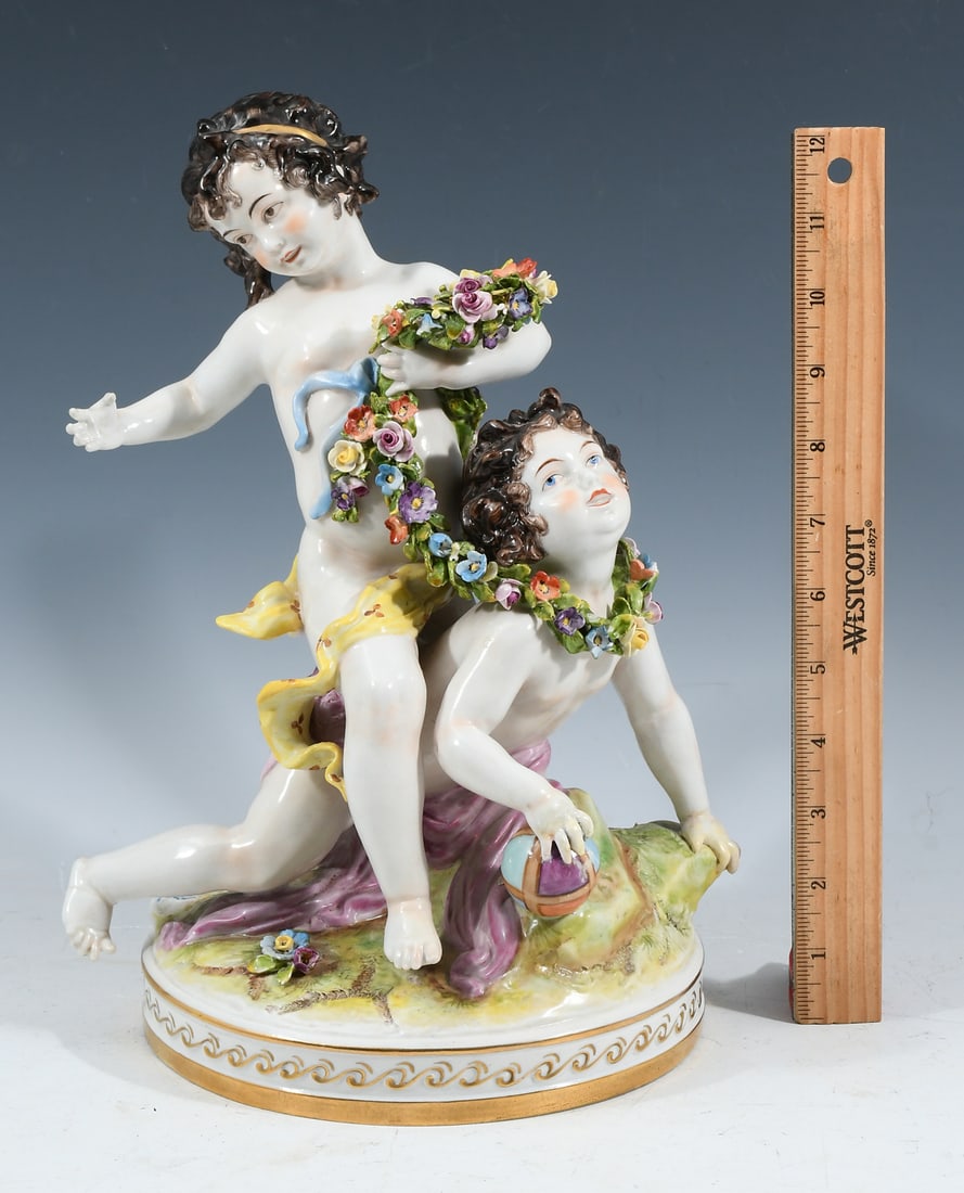 VOLKSTEDT PORCELAIN CHERUB FIGURE: VOLKSTEDT PORCELAIN CHERUB FIGURE: German Volkstedt Porcelain sculpture of playful children with a ball and Floral Garland. Blue Volkstedt mark at the base. Approx. 12.5" h x 8.25" w x 7.5" d.