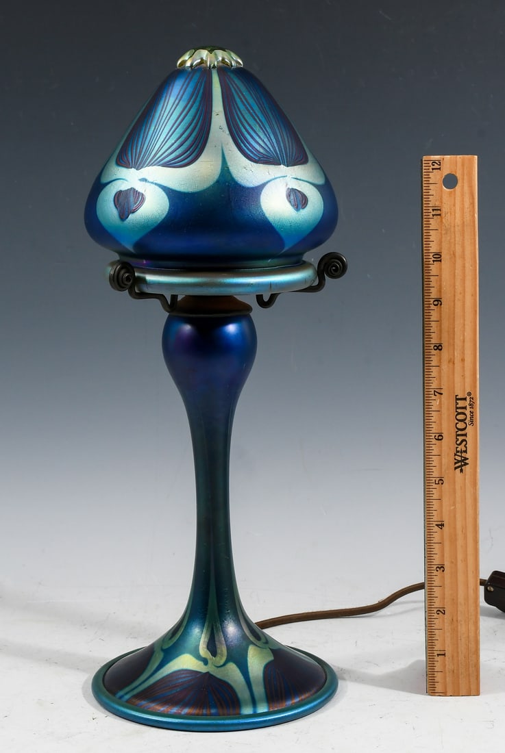 CARL RADKE TIFFANY STYLE MUSHROOM ART GLASS LAMP: CARL RADKE TIFFANY STYLE MUSHROOM ART GLASS LAMP: An art glass table lamp in the style of Carl Radke. "Atomic" mushroom form, base and shade are both signed "L.C. Tiffany - Favrile". Approx. 14.75" h 