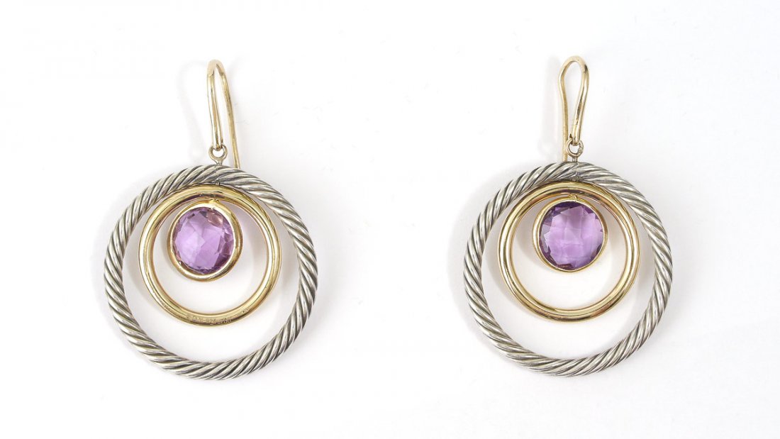 DAVID YURMAN 18K & STERLING AMETHYST EARRINGS: 18K & STERLING AMETHSYT DAVID YURMAN EARRINGS: 18K yellow gold circle spins in a sterling silver circle. At the center are 2 round faceted amethysts. Weight: 5.50 Ct. Approx. Shepherds hooks. Signed D