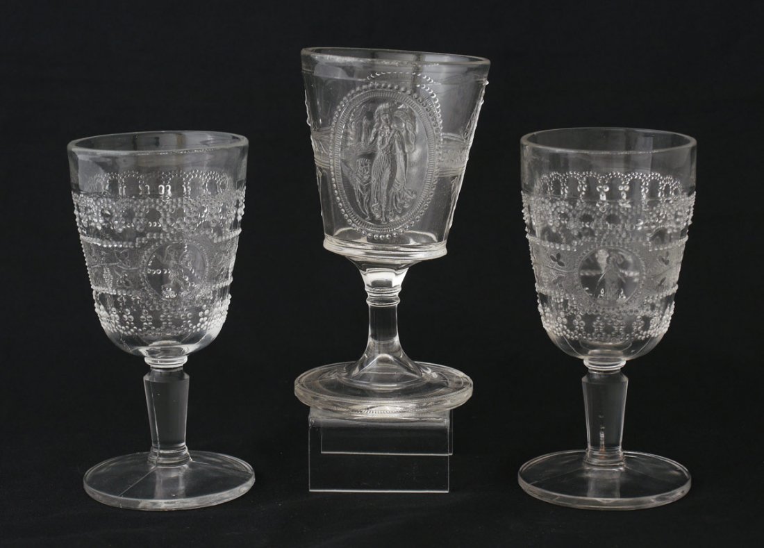 EAPG CHAMPAIGN GLASS MINERVA & CUPID & VENUS: GROUP OF 3 EAPG CHAMPAGNE STEMS: Two in the Minerva pattern and one Cupid & Venus. Measure 5'' tall.