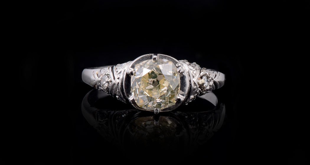 1.20 CT FANCY NATURAL COLOR DIAMOND PLATINUM RING: PLATINUM FANCY COLOR DIAMOND RING: Featuring an old mine cushion cut 1.20 Ct diamond of SI2 clarity and natural fancy brownish yellow. The six accent diamonds total .12 Ct. Size 6.5. Weight 3.4 grams.