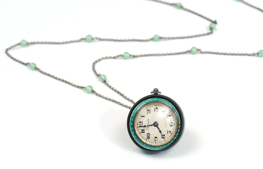 BUCHERER GREEN GUILLOCHE BALL PENDANT WATCH: BUCHERER GREEN GUILLOCHE BALL PENDANT WATCH: Green guilloche case with movement on gimbal to rotate when lifted. Silvered dial marked C. Bucherer. 1" dia. Sold with metal chain with jade colored beads