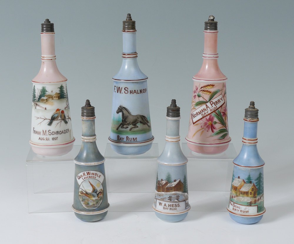 6 MILK GLASS BARBER BOTTLES: GROUP OF 6 MILK GLASS BARBER BOTTLES: Including 3 Bay Rum and Lavender. Measures approx. 8 1/2" - 10". From the William Merner Collection.
