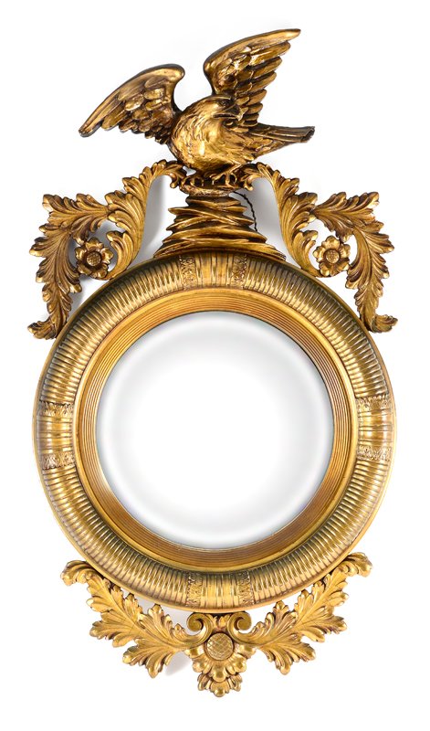 CARVED GILT WOOD EAGLE HALL MIRROR: CARVED GILT WOOD EAGLE HALL MIRROR: Regency style gilt wood frame with eagle finial clutching rocks, foliate swag either side. Fluted frame encircling convex mirror, foliate lower finial. 43'' h. x 24
