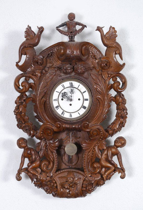 1875 BLACK FOREST CARVED FIGURAL WALL CLOCK: 1875 BLACK FOREST CARVED FIGURAL WALL CLOCK: Figural finial of child with floral garland, case carved with figural birds, fruits, floral swags, garlands and nude figures. Back of lower plaque marked w