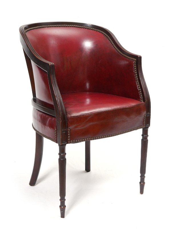 LEATHER BARREL SHERATON STYLE CHAIR: LEATHER BARREL SHERATON STYLE CHAIR: Fluted top rail continues to supports, fluted front legs. Tacked burgundy leather upholstery, overall measures 35" h. x 21" x 21 1/2". Estate of Elton Hoyt II