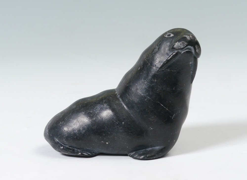 INUIT CARVED WALRUS BY MOSES ECHALOK: INUIT CARVED WALRUS BY MOSES ECHALOK: Carved stone, 4 1/2" h. x 5 1/2" w., label affixed.