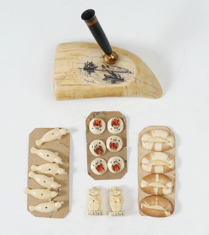COLLECTION OF ALASKAN IVORY ITEMS: COLLECTION OF ALASKAN IVORY ITEMS: To include 1) Nuguruk signed scrimshaw whales tooth pen holder, scene of Iniut fisherman in his kayak. 5" long, x 2 1/2". 2) 6 figural seal buttons, 1 1/2". 3) 4 but