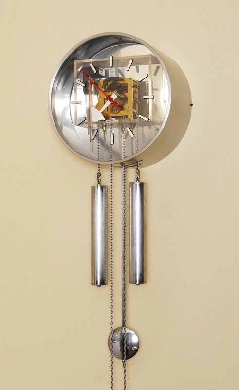 GEORGE NELSON FOR HOWARD MILLER WALL CLOCK: GEORGE NELSON FOR HOWARD MILLER WALL CLOCK: Brushed metal case with clear Lexan face revealing movement, applied time marks. Weight driven time and strike movement, case measures 12" dia. x 6 1/2".