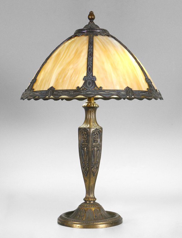 SAIL BROTHERS BENT PANEL SLAG GLASS LAMP: SAIL BROTHERS BENT PANEL SLAG GLASS LAMP: Patinated metal with floral and flaming torched motif, double socket fixture. 23 1/2" h. x 7 1/2". 6 caramel slag glass bent panel shade with filigree, 8 3/4"