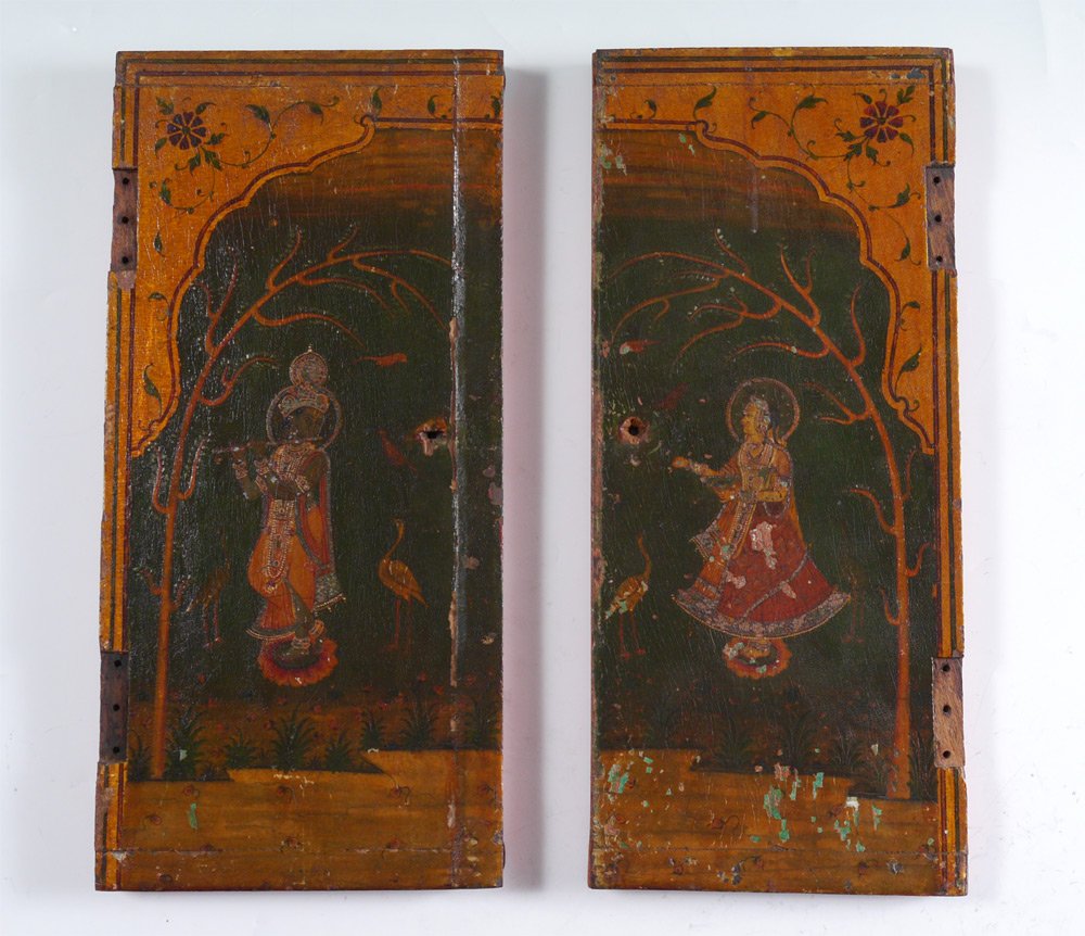 PAIR PAINTED INDIAN CABINET DOORS: PAIR PAINTED INDIAN CABINET DOORS: Paint decorated with figure on man playing a flute on one, woman standing on the other, both with trees and birds. Iron supports, each mounted for wall hanging on th