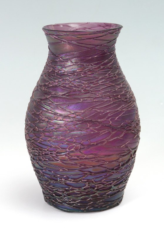 KRALIK IRIDESCENT THREADED GLASS VASE: KRALIK IRIDESCENT THREADED GLASS VASE: Unmarked, attributed to Kralik, baluster form purple iridescent glass vase with applied threading. Overall measures 8 3/8" h. x 5 1/4".