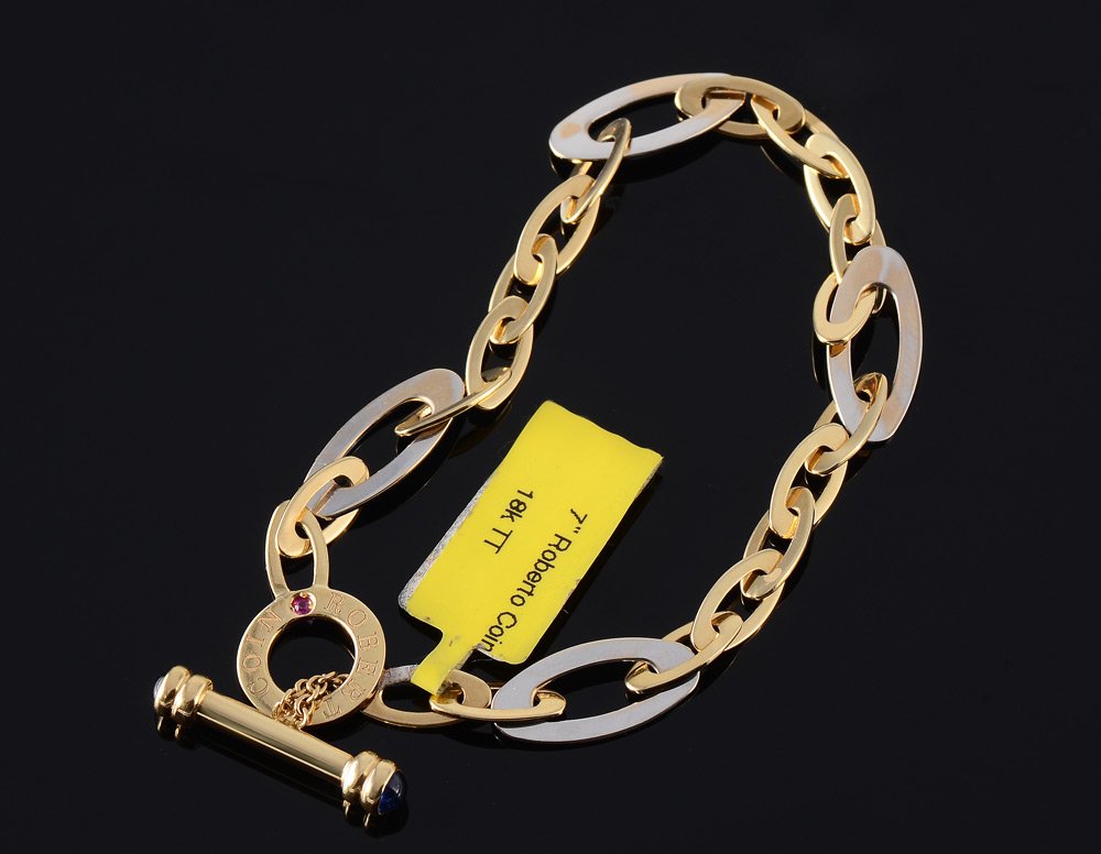 ROBRTO COIN 18K TWO TONE GOLD LINK BRACELET: VINTAGE ROBERTO COIN GOLD LINK BRACELET: 18k yellow and white open link bracelet with sapphire bullets in the toggle bar. Signed Roberto Coin and bears the signature ruby. Length 7". Weight 10.5 grams