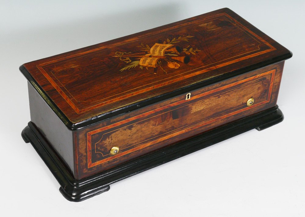 SWISS CYLINDER ROLL MUSIC BOX CASE: SWISS CYLINDER ROLL MUSIC BOX CASE: Case only with inlaid musical instruments and sheet music on hinged lid, string inlay on lid and sides. 8" h. x 24 1/2" x 11".