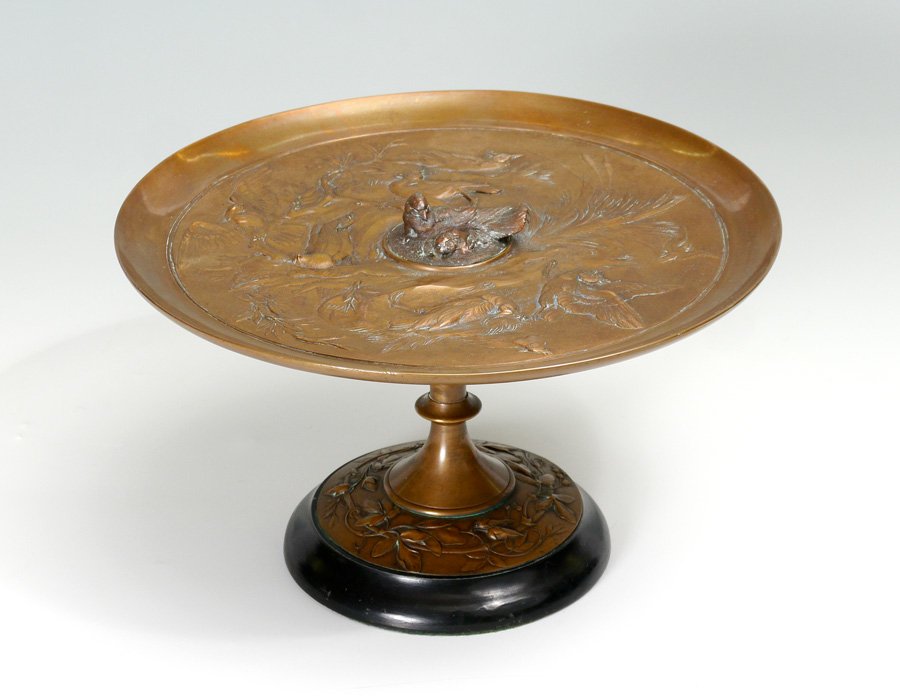 BIRD MOTIF BRONZE TAZZA: BIRD MOTIF BRONZE TAZZA: Figural bird motif bowl with relief bird in center medallion, base with vine motif. No visible signature or makers mark. Overall measures 6 1/2'' h. x 11''.
