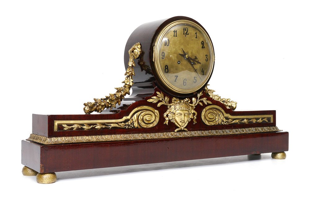 ORMOLU AND MAHOGANY CONTINENTAL MANTLE CLOCK: ORMOLU AND MAHOGANY CONTINENTAL MANTLE CLOCK: Mahogany veneer case and stand with applied gilt metal decoration including floral swags, masqueron and acanthus leaf trim, on 4 gilt metal feet. Brass di