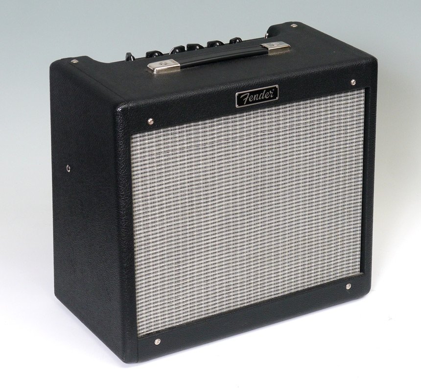 FENDER BLUES JUNIOR AMPLIFIER: FENDER BLUES JUNIOR AMPLIFIER: Tube amplifier by Fender, serial number B-361646, made in Mexico. Sold with the foot pedal & original cover. 16" h. x 18 1/4" x 9".
