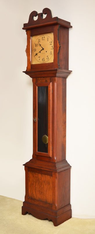 ITHACA MAHOGANY LONG CASE CLOCK: ITHACA MAHOGANY LONG CASE CLOCK: Broken arch pediment with urn finial, shaped top door, glass front door, stepped base with shaped skirt. Heavy paper dial with Arabic numerals, marked Ithaca. Overall