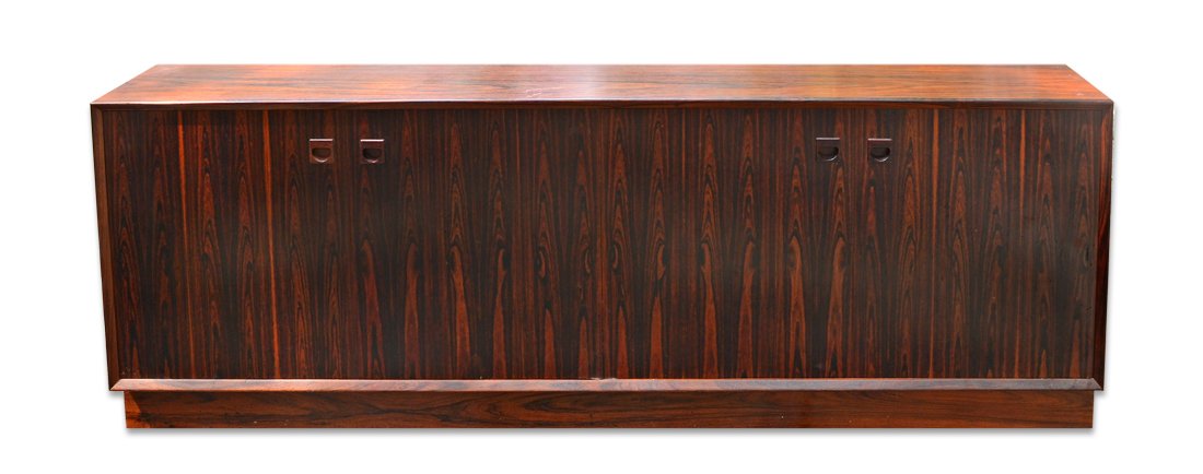 DANSK ROSEWOOD MID CENTURY ROSEWOOD CREDENZA: DANSK ROSEWOOD MID CENTURY ROSEWOOD CREDENZA: Each side with slide out doors, left side open storage, right side with shelves and drawers. Overall measures 27 1/2'' h. x 76 3/4'' x 19 3/4''.