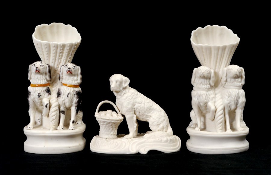 PARIAN BENNINGTON DOG SPILL VASES AND FIGURINE: PARIAN BENNINGTON DOG SPILL VASES AND FIGURINE: 3 pieces total to include 1-2) Paint decorated and unpainted spill vases featuring 2 spaniels, unmarked, 7 7/8" h. x 4" x 5". 2) Single dog with basket 