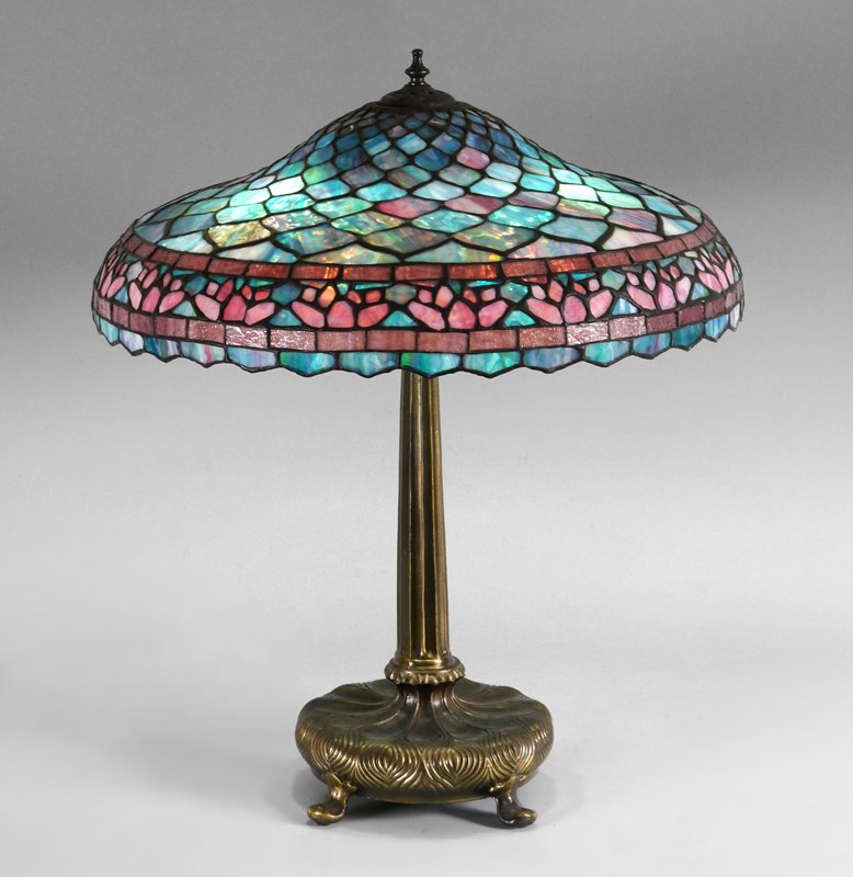 CONTEMPORARY LEADED GLASS LAMP: CONTEMPORARY LEADED GLASS LAMP: Patinated metal base on 4 feet, 3 socket fixture, 27" h., illegible mark on base. Leaded glass shade with pinks, blues and whites, 7 1/2" h. x 22 1/2" diameter.