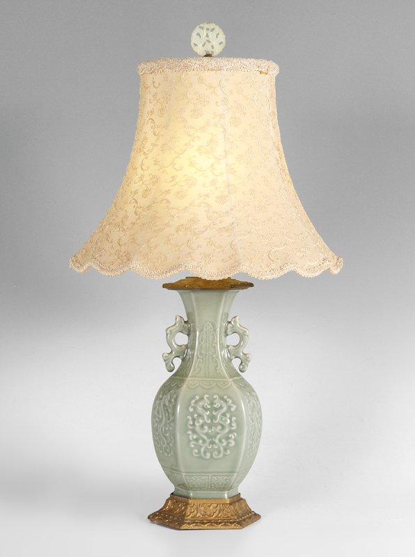 CHINESE CELADON LAMP: CHINESE CELADON LAMP: Celadon earthenware vase converted to light with embossed figural dragons, applied handles. Gilt cast metal base and top, single socket fixture, carved stone finial. 28" h. x 6 1