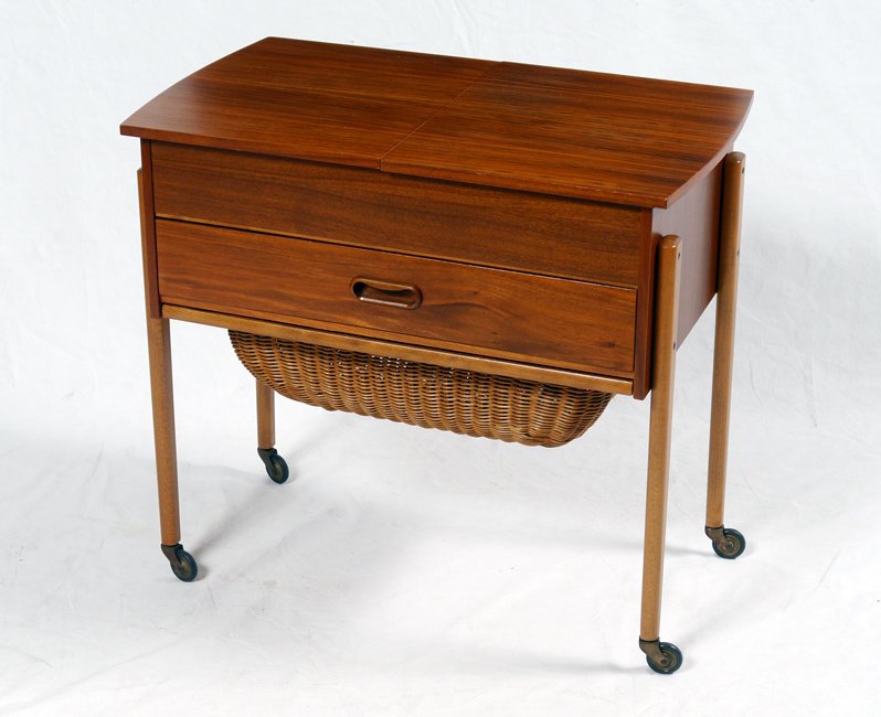 EMC MOBLER DANISH TEAK SEWING STAND: EMC MOBLER DANISH TEAK SEWING STAND: Attributed to EMC Mobler, sliding top with compartmented interior over single drawer over slide out basket. All on castors, approx. 22" h. x 24 1/4" x 14 1/4".
