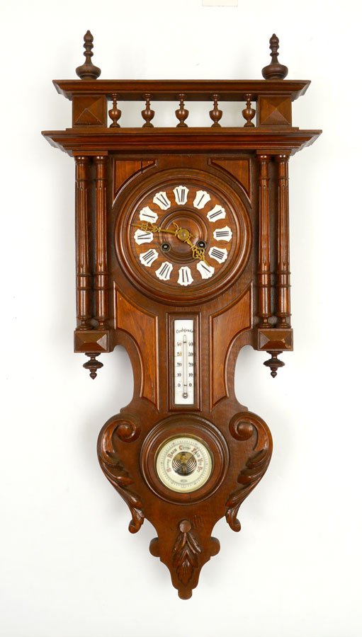 WALNUT WALL CLOCK WITH BAROMETER: WALNUT WALL CLOCK WITH BAROMETER: Walnut case, stick and ball pediment, body with fluted full column decoration, carved lower finial. Dial with Roman numeral in enameled medallions, inset thermometer