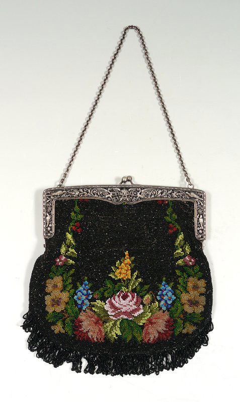 VINTAGE BEADED PURSE W/ SILVER FRAME: VINTAGE BEADED PURSE WITH SILVER FRAME: Floral design on black ground with fringe. The continental 800 silver frame is embossed in a bird and dragon motif centering a roaring masqueron. The interior w