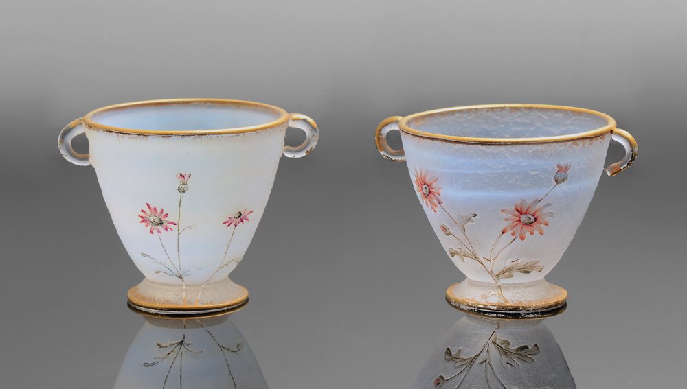 PAIR DIMINUTIVE DAUM NANCY CAMEO CUT CUPS: PAIR DIMINUTIVE DAUM NANCY CAMEO CUT CUPS: One carved with stork and floral motif, the other with duck and floral motif. Each with double handles, gilt trim, signed on base Daum Nancy. 1 1/2'' h. x 2