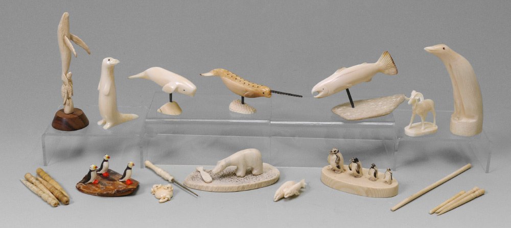 COLLECTION OF CARVED WALRUS IVORY ITEMS: COLLECTION OF CARVED WALRUS IVORY ITEMS: An assembled collection of Northwest & Inuit tourist pieces from walrus tusk and whales teeth to include figural salmon, narwhal, beluga whale, penguins, polar